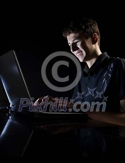Teenager chatting in a dark room Teenager chatting in a dark room