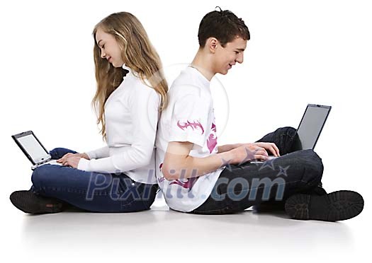 Couple of teenagers sitting on the floor with laptops Couple of teenagers sitting on the floor with laptops