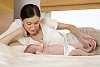 Woman and a small baby spending time on the bed