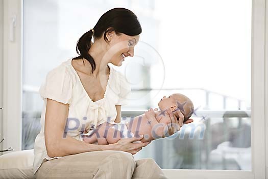 Woman sitting and holding a little baby Woman sitting and holding a little baby