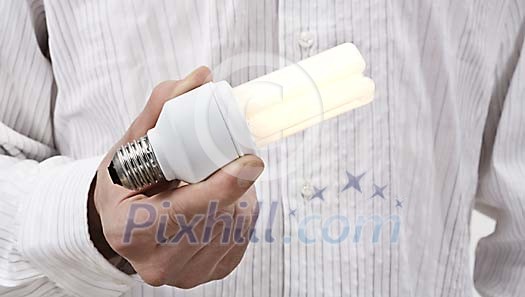 Male hand holding a lighted light bulb Male hand holding a lighted light bulb