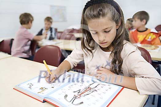Girl in the classroom writing Girl in the classroom writing