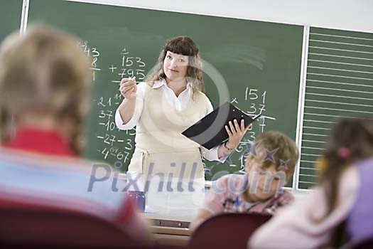 Female teacher standing in front of the class Female teacher standing in front of the class
