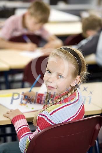 Young girl sitting in the classroom Young girl sitting in the classroom