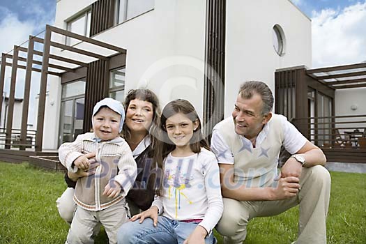 Family posing in front of a house