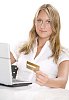 Woman sitting behind a laptop with a credit card in her hand