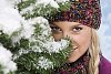 Woman peeking behind snowy branches