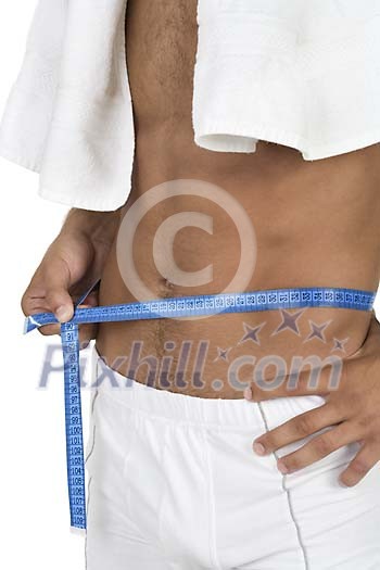 Isolated man measuring his waist Isolated man measuring his waist
