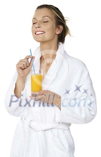 Woman in bathrobe enjoying a glass of juice Woman in bathrobe enjoying a glass of juice