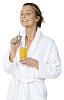 Woman in bathrobe enjoying a glass of juice