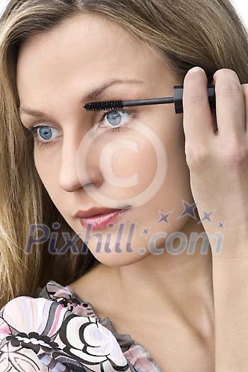 Woman putting on mascara Woman putting on mascara