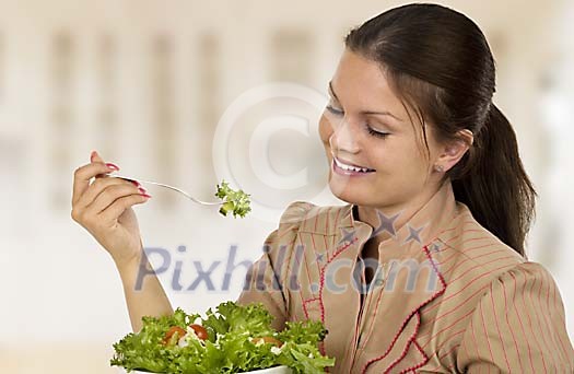 Woman eating a green salad Woman eating a green salad