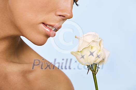 Woman smelling a light pink rose Woman smelling a light pink rose