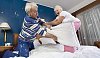 Senior couple having a pillow fight on the bed