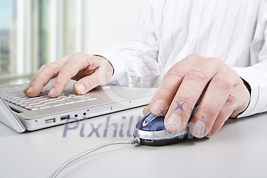 Male hands on a mouse and a keyboard Male hands on a mouse and a keyboard