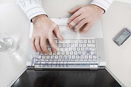 Male hands on a laptop keyboard Male hands on a laptop keyboard