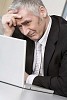 Older businessman looking tired at his desk