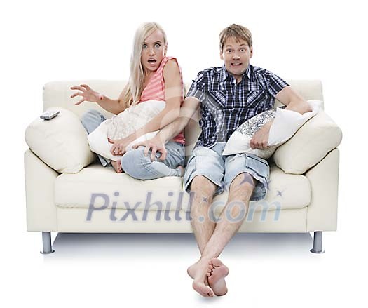 Isolated couple on the couch looking scared Isolated couple on the couch looking scared