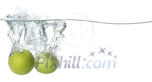 Two green apples diving in to the water Two green apples diving in to the water