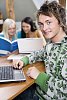 Male teenager with a laptop in the classroom