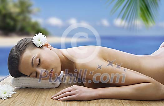 Beautiful woman ready for massage in tropical paradise Beautiful woman ready for massage in tropical paradise