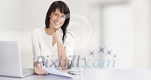 Business woman by her desk with laptop and mobile Business woman by her desk with laptop and mobile