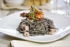 Exotic black pasta with sea food in restaurant