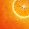 Fresh slice of orange with cool drops on orange background