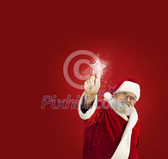 Santa Claus touching a magic Christmas star Santa Claus touching a magic Christmas star