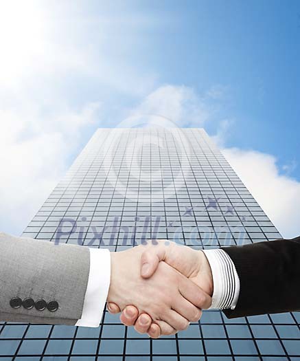 Handshake in front of a business building Handshake in front of a business building