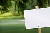 Empty sign on a green yard