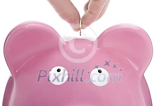 Hand inserting a coin to the piggy-bank Hand inserting a coin to the piggy-bank