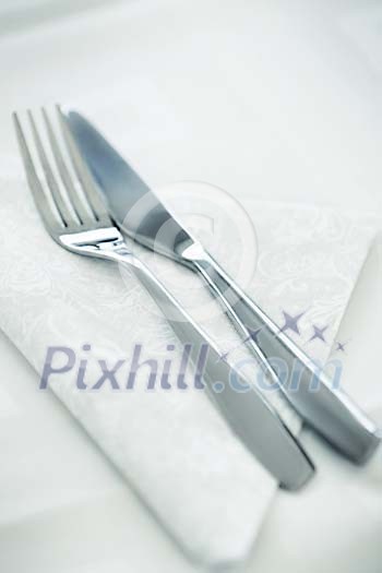 Fork and a knife on a white napkin Fork and a knife on a white napkin