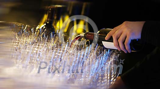 Pouring red wine to the glasses Pouring red wine to the glasses