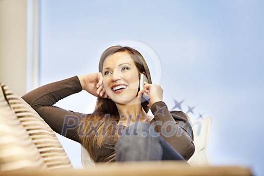 Woman on the couch talking to a phone Woman on the couch talking to a phone