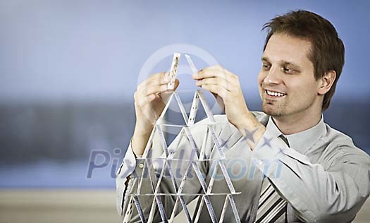 Businessman building a house of cards Businessman building a house of cards