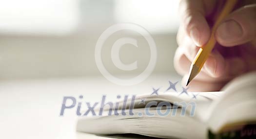 Hand holding a pen and writing Hand holding a pen and writing