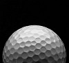 Golfball on a dark blackened background