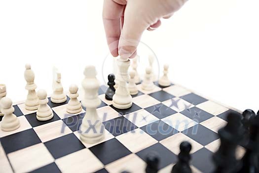 Hand lifting a queen on chessboard Hand lifting a queen on chessboard