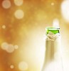 Opened champagne bottleneck on a golden background