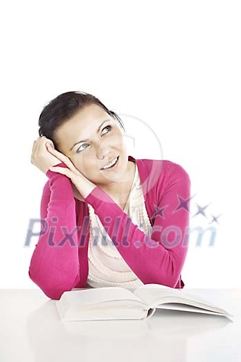 Woman sitting at the desk with a book and looking up Woman sitting at the desk with a book and looking up