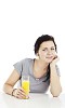 Woman sitting by the table, drinking juice
