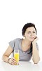 Woman sitting by the table, drinking juice