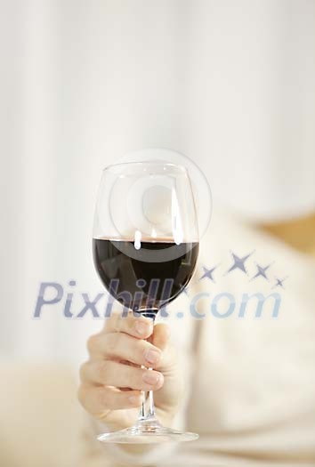 Hand holding a glass of red wine Hand holding a glass of red wine