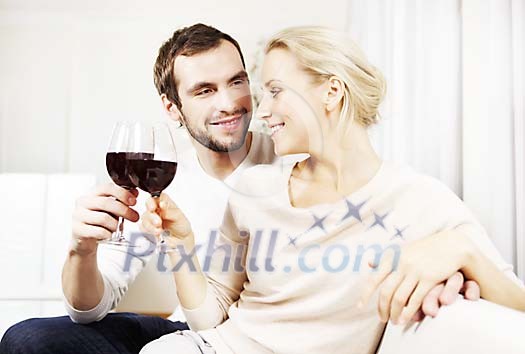 Couple sitting on the couch having a glass of wine Couple sitting on the couch having a glass of wine