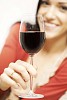 Woman holding a glass of red wine close to the camera