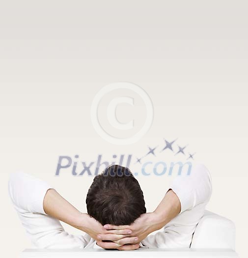 Man sitting with his back to the camera, hands on his head Man sitting with his back to the camera, hands on his head