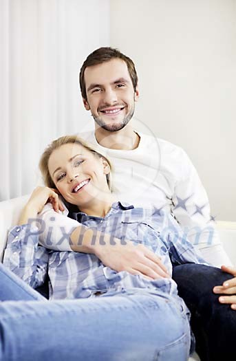 Happy couple smiling on the sofa Happy couple smiling on the sofa