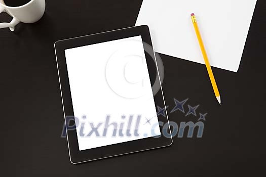 Tablet computer and piece of paper on the desk Tablet computer and piece of paper on the desk