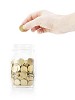 Isolated hand putting a coin in the glass jar